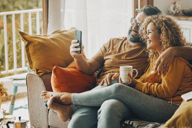 Pareja sentada en sofá con decoración de otoño